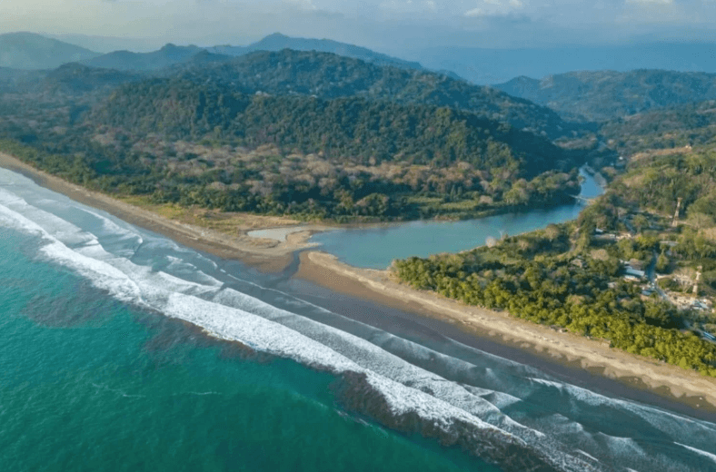 Pristine Pacific ocean meeting the rainforest of Dominical river mouth.